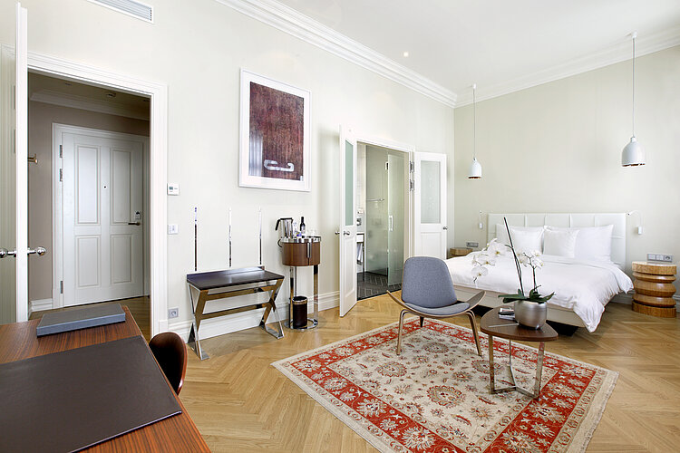 Chambre d’hôtel avec WC sans bride et porte de salle de bain ouverte