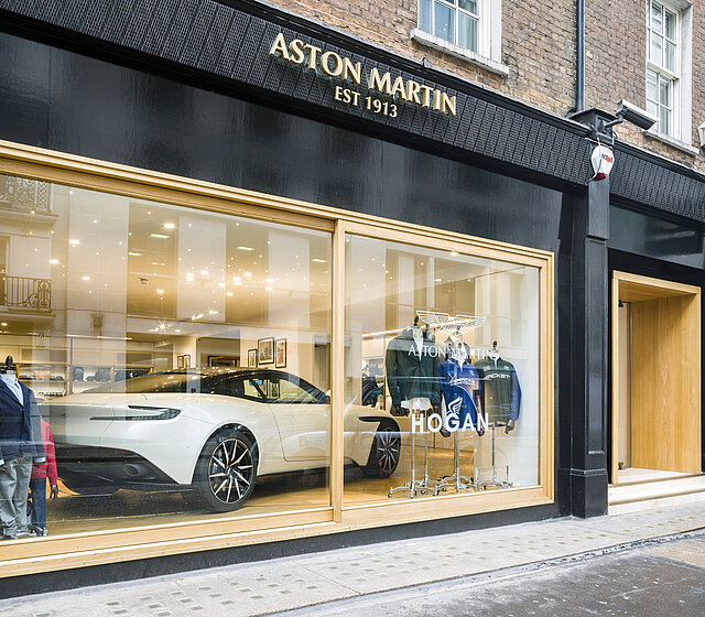 Vue dans une vitrine dans laquelle une voiture de sport blanche est présentée