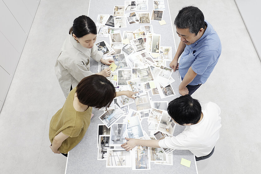 Penchées sur une table, quatre personnes discutent de différentes images _DSA8595_z.jpg