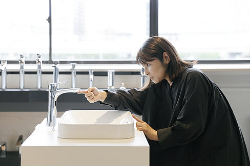 Une femme vérifie la forme d'un robinet. _DSA0113_z.jpg