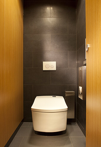 Wall-mounted WASHLET® SE against dark tiles