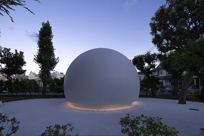 Vue extérieure des toilettes de Nanagodori. La maison a la forme d'une sphère. La sphère est éclairée par le bas.