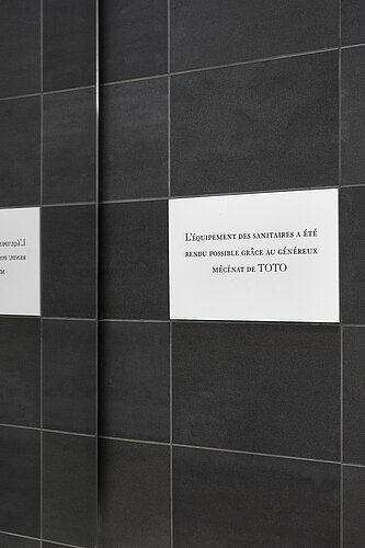 Public restroom with urinals and stalls at Louvre Museum in Paris