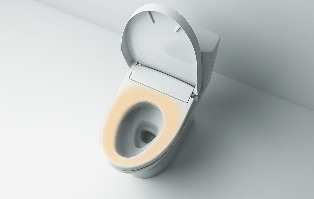 The picture shows a washlet from above. The lid is open. The seat is highlighted in orange. 