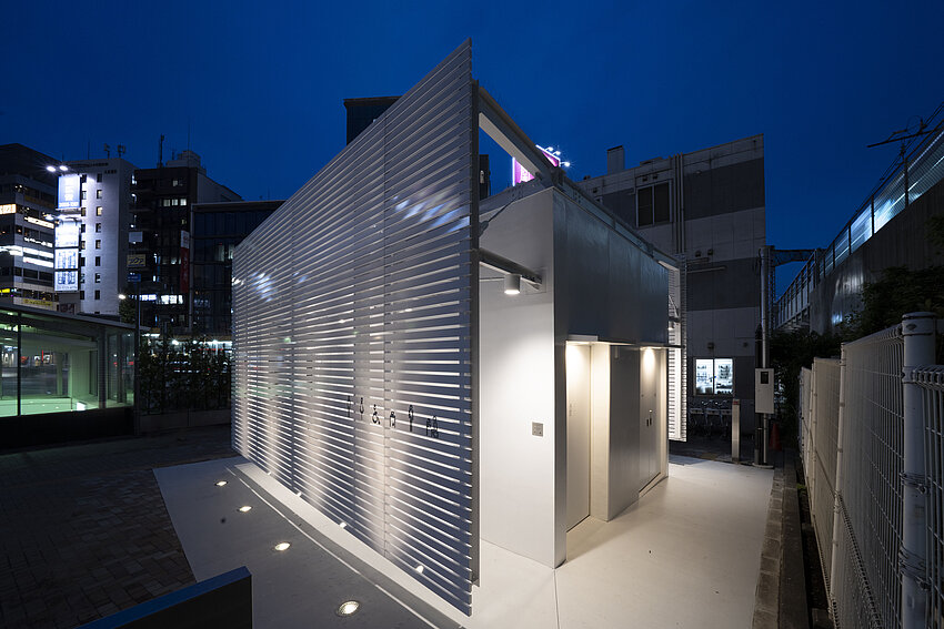 Exterior view of the toilet house at night. 