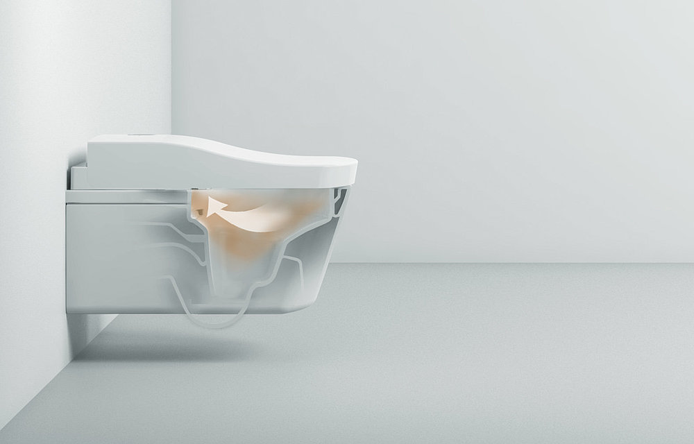 The picture shows a toilet with a washlet. It is transparent in the middle so that you can see inside. A brown cloud is shown inside and a white arrow indicates that the air is being sucked into the washlet. 