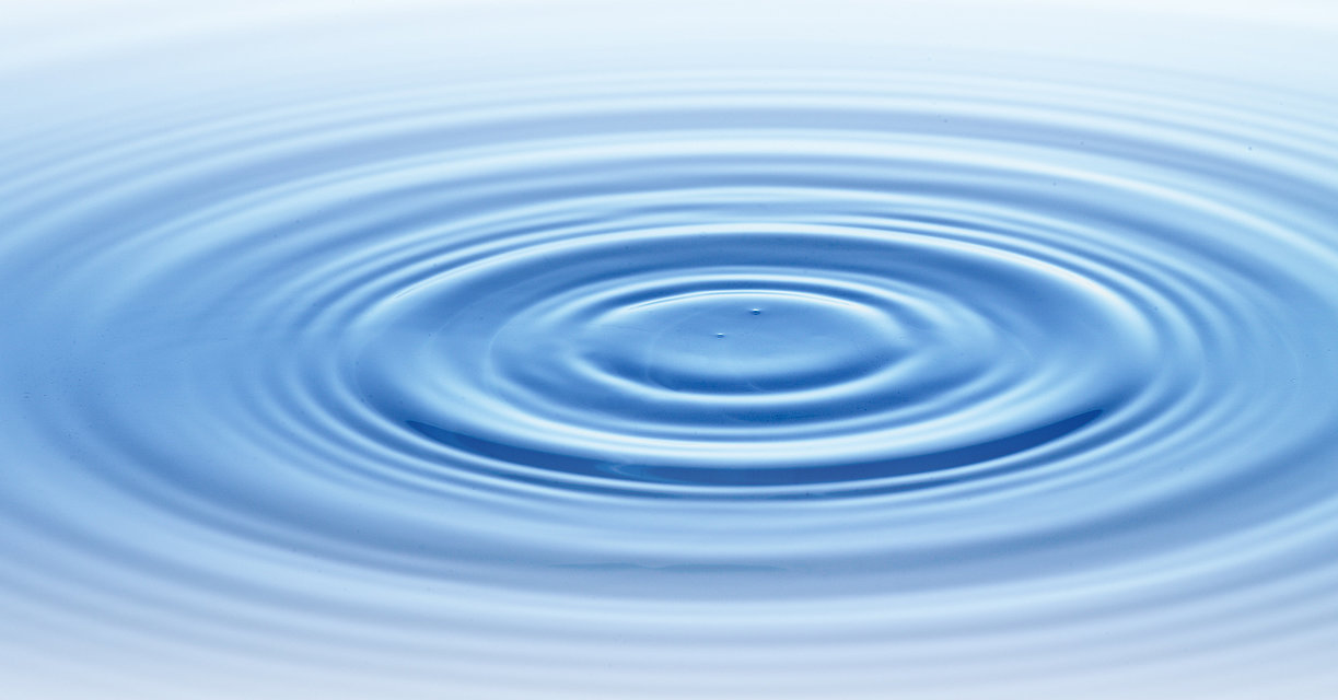 The picture shows a water surface on which rings form. It starts with a small ring in the center. Around it are larger rings of water at different distances.