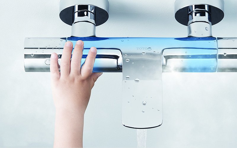 Child touches faucet with SAFETY THERMO
