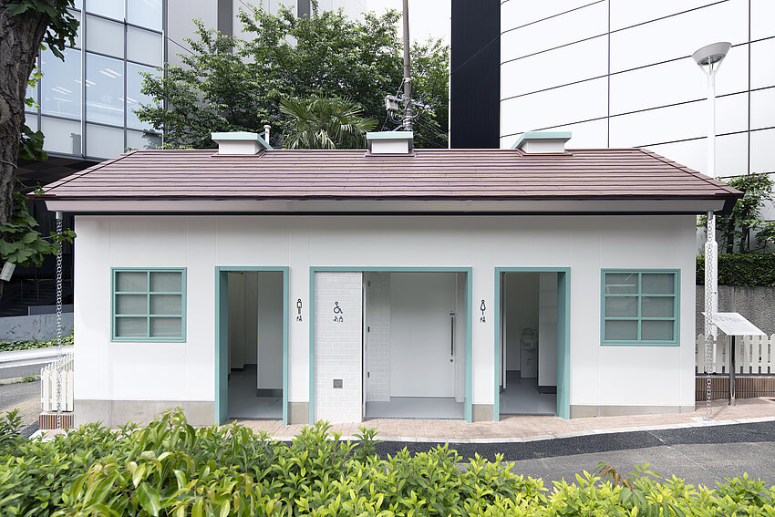 Außenansicht des Toilettenhäuschen in Jingumae. Das Häuschen sieht aus wie ein Gartenhaus.