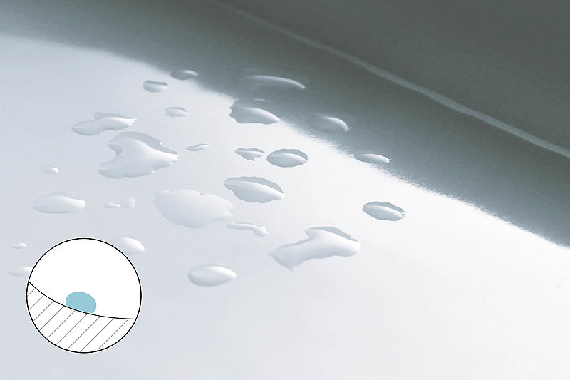 Here is an illustration of a hydrophobic ceramic. The water droplets remain on the surface in their droplet form and do not spread out. In the bottom left-hand corner is a schematic representation of the hydrophobic property of the ceramic. The drop of water forms a drop shape on the surface. 