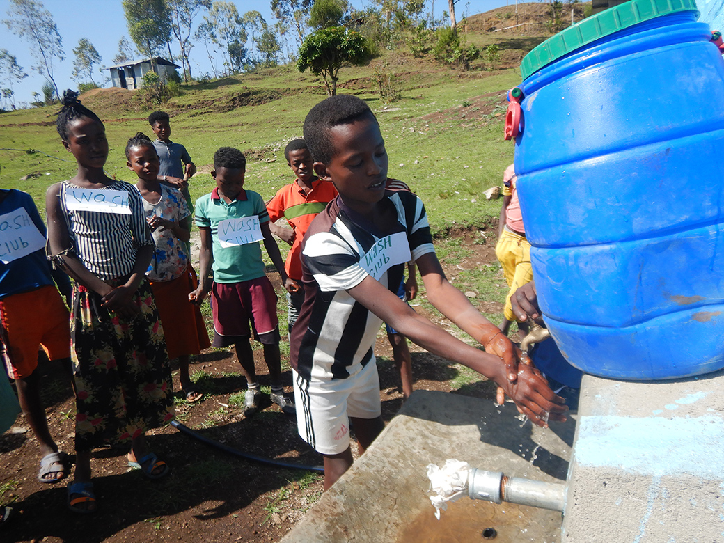 People are washing their hands at a hand-washing station installed by by TOTO Water Environment Fund grantee organization