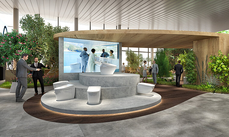The image is a visualization of a TOTO booth at ISH, showcasing a series of state-of-the-art toilets on a central raised platform surrounded by a naturalistic design with plants and trees. Visitors can move around the exhibition in a semi-circle, while a large screen in the background shows the bathroom experience in action.