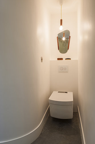 Vue d’une salle de bain avec des toilettes sans bride et un lavabo
