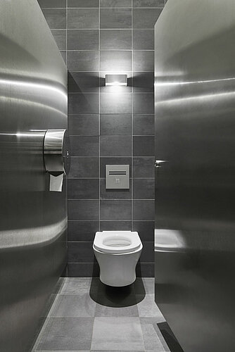 Anthracite-colored toilet area with white vanities and hand dryers