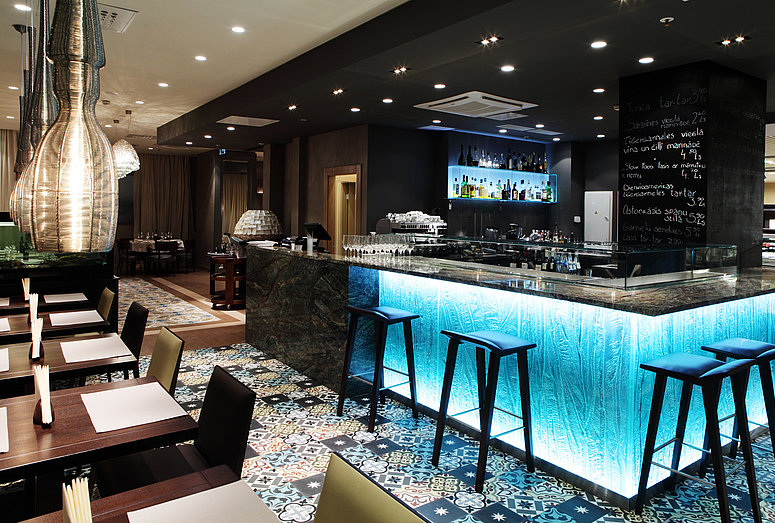 [Translate to Deutsch:] Blue-lit hotel bar at Gastronome Riga Restaurant