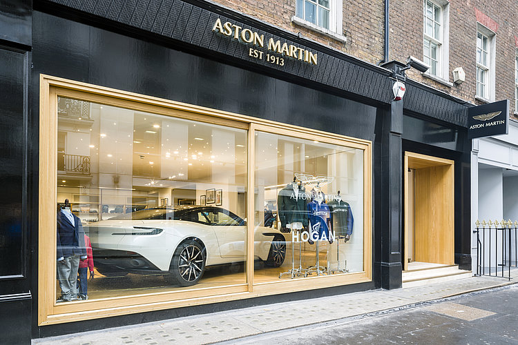 View into a shop window in which a white sports car is presented