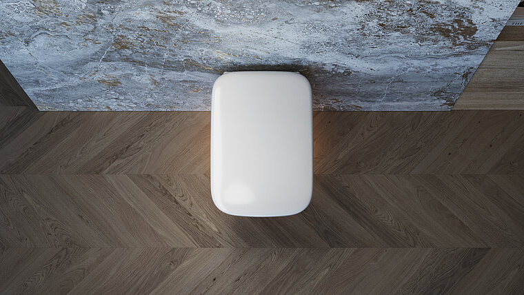 Das Foto zeigt eine Draufsicht auf eine geschlossene, wandhängende Toilette auf einem Holzfußboden, direkt unterhalb einer beeindruckenden, gemusterten Marmorwand. Die Perspektive gibt einen einzigartigen Blick auf das schlanke Design der Toilette und die Textur der Materialien im Badezimmer.