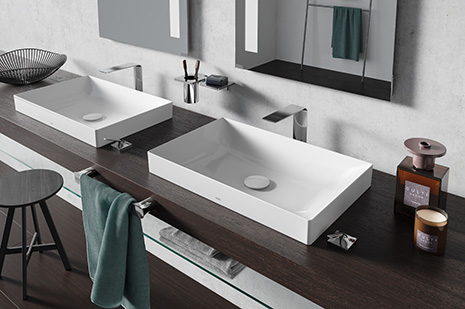 Elegant washbasins with designer fittings in front of a large window front